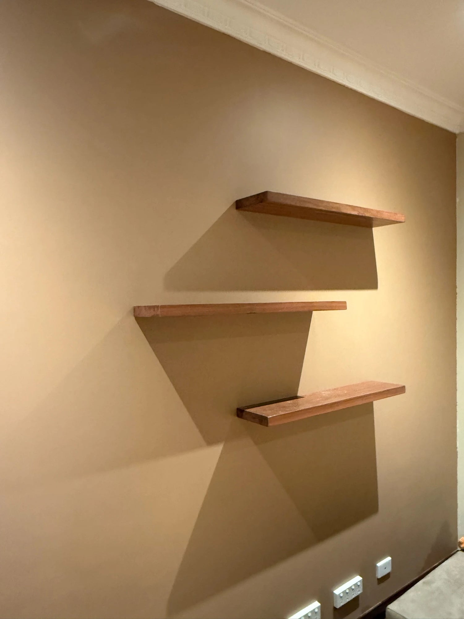 Three wooden shelves mounted on a wall