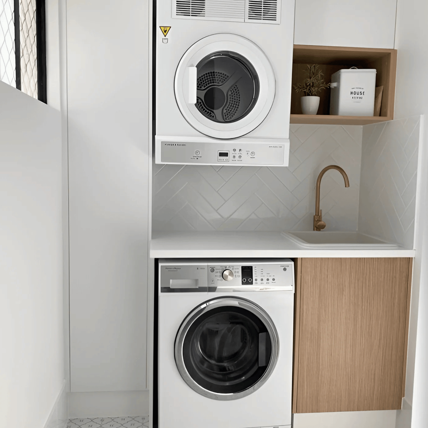 The Hangmaster technician mounting a dryer on the wall above a washing machine.